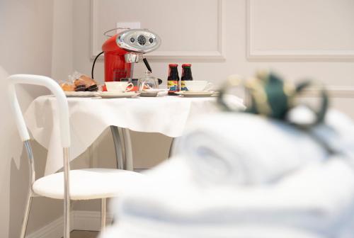 een tafel met een koffiezetapparaat en kopjes erop bij Residence Briona in Domodossola