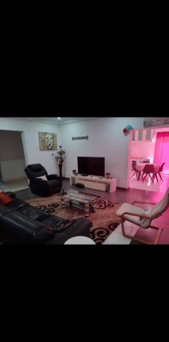 Wizzos Guesthouse في Sukuta: غرفة معيشة بها أريكة وطاولة