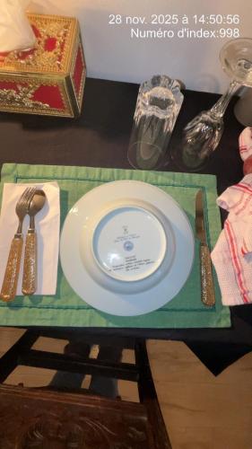 einen Tisch mit einem Teller und Küchenutensilien darauf in der Unterkunft Booking94 in Villeneuve-Saint-Georges