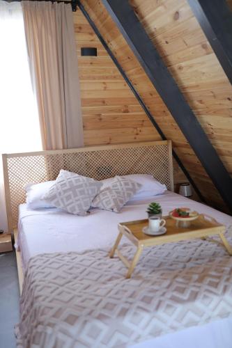 a bedroom with a bed with a table on it at Beloris Bungalov in Erenköy