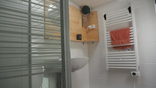 een badkamer met een wastafel en een glazen douchedeur bij La Vache Bleue in Saint-Pierre-de-Fursac