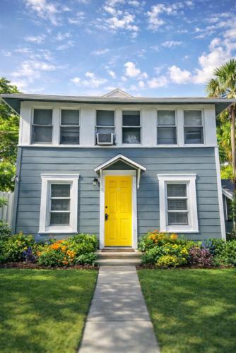 a blue house with a yellow door in a yard at St Pete Room hub in St. Petersburg