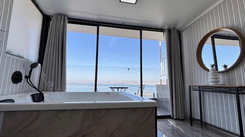 a bath tub in a bathroom with a large window at פרמיום בכינרת in Tiberias