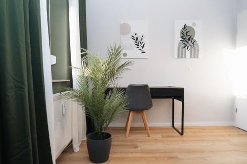 una scrivania con sedia e una pianta in una stanza di DAS GRÜNE NEST Münsterland Living a Drensteinfurt