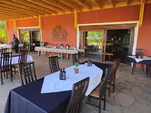 ein Esszimmer mit Tischen und Stühlen in einem Raum in der Unterkunft Auas Safari Lodge in Windhoek