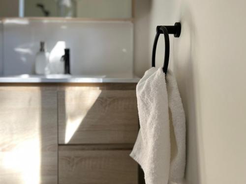 ein weißes Handtuch, das in einem Badezimmer an einem Handtuchhalter hängt in der Unterkunft Castlemaine Short Stays in Castlemaine