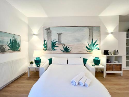 a bedroom with a white bed with two towels at Mimosa Seafront Apartment - Free parking Wi-Fi in Varazze
