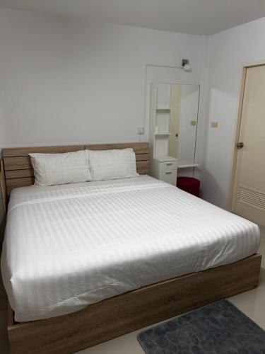 een slaapkamer met een groot bed met witte lakens bij Sleepwell at naiyang No2 in Nai Yang Beach