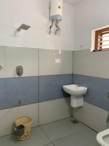 a bathroom with a sink and a toilet at Elysian in Mananthavady