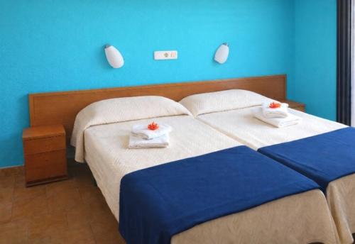 een blauwe slaapkamer met een bed met handdoeken erop bij San Jordi Tossa de Mar in Tossa de Mar