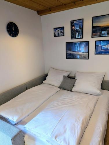 a bed in a room with a clock on the wall at Geigerhof Bad Heilbrunn in Bad Heilbrunn