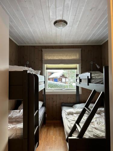 a room with three bunk beds and a window at Leilighet Ski in/out, golf in Vradal