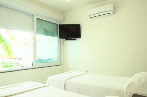 a hospital room with two beds and a window at Villa dos Graffitis Pousada in Morro de São Paulo