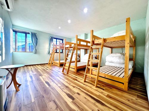 a room with three bunk beds and a table at 富士Base御殿場 Station-Side Hideout in Gotemba
