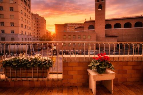 een balkon met 2 potten bloemen en een bank bij Lucens Domus Appartamento Roma quartiere Trieste - vicino Metro b1 - in Rome