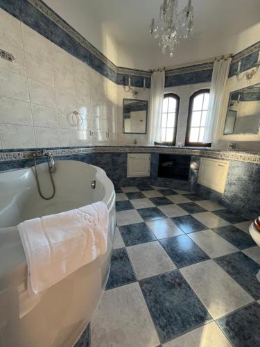 een badkamer met een bad en een geruite vloer bij Pension Libra in Velešín