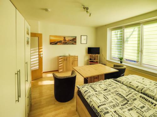 een slaapkamer met een bed, een tafel en een bureau bij FEWO Jänschwalde II in Jänschwalde Ost