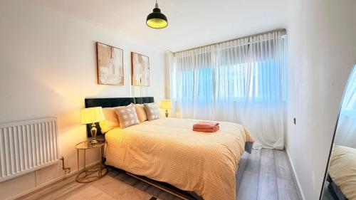 une chambre avec un lit avec deux lampes et une fenêtre dans l'établissement Modern 1 bed super fast WiFi, à Brentford