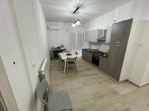 une cuisine avec une table et des chaises ainsi qu'une salle à manger dans l'établissement La Casa di Giada, à San Cataldo