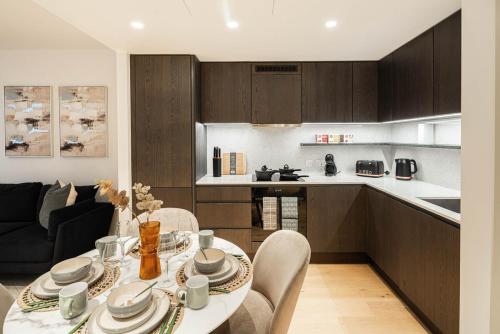 a kitchen and living room with a table and chairs at Stylish 1BR Escape - Gym -Balcony - Lift in London