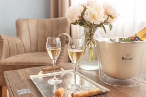 two glasses of white wine on a table with flowers at freustil Boutique Hotel in Binz
