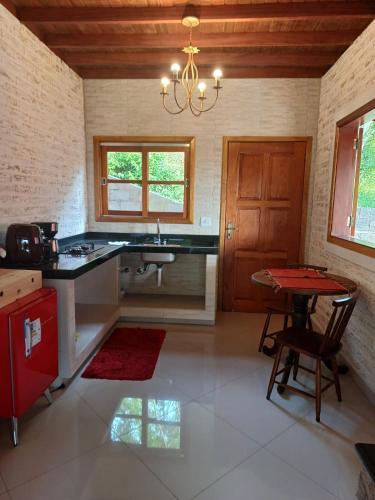 una cucina con lavandino e tavolo in una stanza di Chalés Maktub a Camanducaia