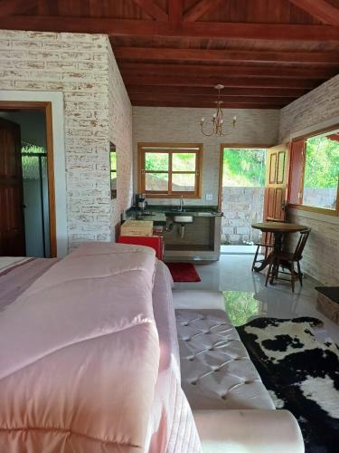 una camera da letto con un letto e un bagno con un lavandino di Chalés Maktub a Camanducaia