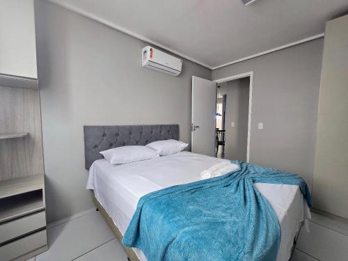 een slaapkamer met een bed met een blauwe deken erop bij Ed. Manoel Cordeiro - Stúdio Meu aconchego II in Caruaru