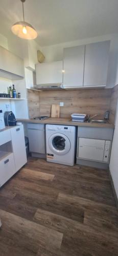 een keuken met een fornuis en een wasmachine bij Studio à 10min à pieds des Cures in Gréoux-les-Bains