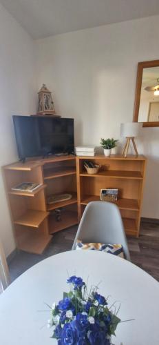 een kamer met een tafel met een tv en een bureau bij Studio à 10min à pieds des Cures in Gréoux-les-Bains