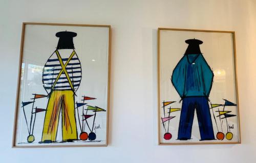 two paintings of clothes are hanging on a wall at L'esprit vacances-T3 à Port La Forêt in La Forêt-Fouesnant