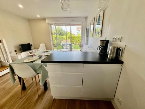 a kitchen with a counter and a table with chairs at L'esprit vacances-T3 à Port La Forêt in La Forêt-Fouesnant