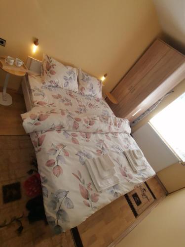 a small bedroom with a bed with flowers on it at Mala Sirena in Pirot