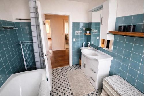 een badkamer met een bad en een wastafel en een ligbad bij Haus am Bodensee in Fußach
