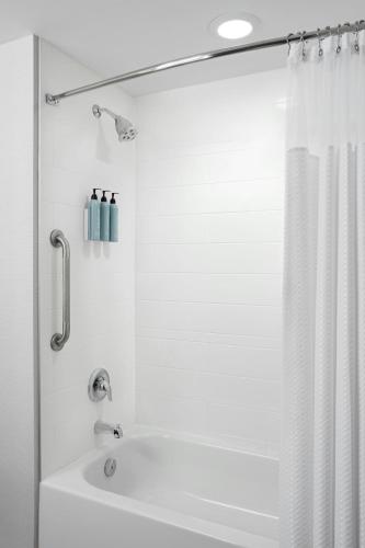 a bathroom with a shower with a white shower curtain at Courtyard by Marriott Mississauga-Airport Corporate Centre West in Mississauga