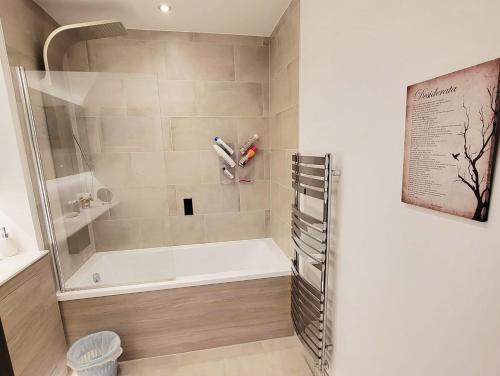 a bathroom with a tub with two toothbrushes at Host-Free Ensuite Double Bed by Heathrow in Feltham