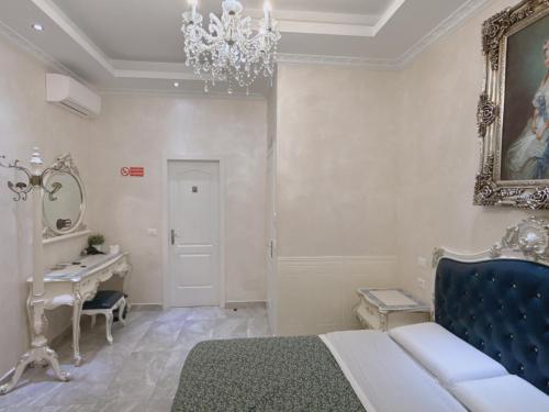 a bedroom with a bed and a vanity and a chandelier at innstation guesthouse in Rome