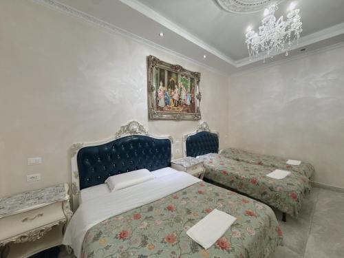 a bedroom with two beds and a painting on the wall at innstation guesthouse in Rome