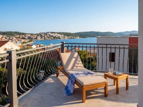 a balcony with a chair and a view of the water at Apartmani Attila in Trogir