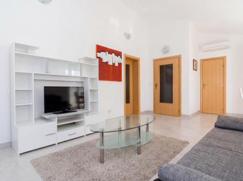 a living room with a tv and a glass coffee table at Apartmani Attila in Trogir