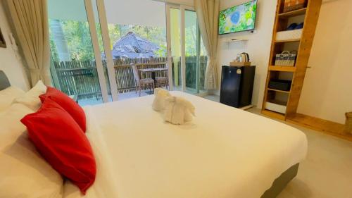 a bedroom with a large white bed with red pillows at Beautiful Bungalow 5, Koh Chang in Ban Dan Mai