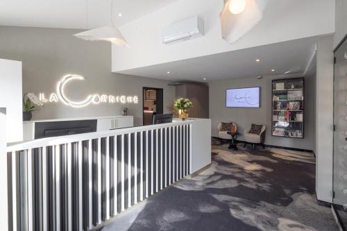 a lobby with a staircase with a sign on the wall at LaCorniche Hôtel in Contrexéville