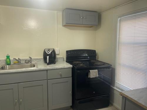 a kitchen with a black stove and a sink at St Pete Room hub in St. Petersburg