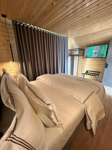 a bedroom with a bed with white sheets and pillows at Hotel McPietroasa in Haleş