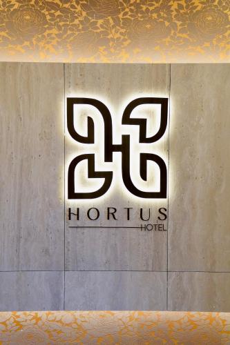 a sign for a hortus hotel on a wall at Hortus Hotel Tirana in Tirana