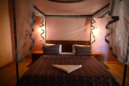 a bedroom with a bed with a canopy at Hotel le Mbosse in Niaga