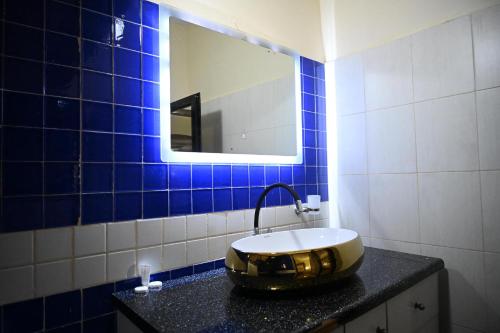 a bathroom with a bowl sink and a mirror at Hotel le Mbosse in Niaga