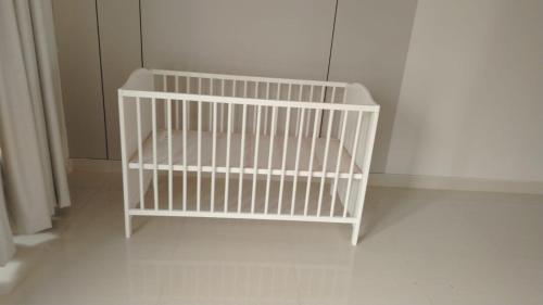 een witte wieg in de hoek van een kamer bij مخيم المشراف in Al Raka