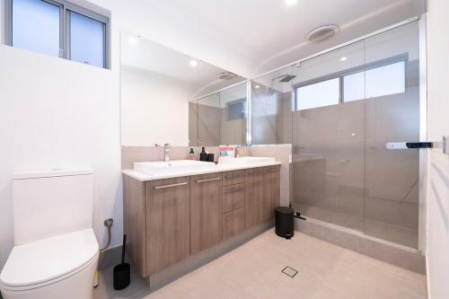 a bathroom with a toilet and a sink and a shower at Henley Brook - Finest in Henley Brook