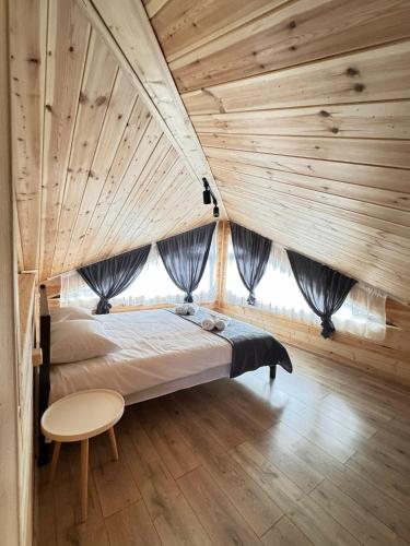 a bedroom with a large bed in a wooden ceiling at Cottage Liantto in Borjomi